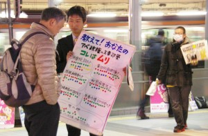 駅前のお帰りなさい宣伝でシールアンケートへの協力をよびかける羽鳥だいすけ中野区議予定候補と青年後援会員=5日午後7時、東京都中野区