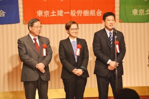 東京土建の旗びらきであいさつする(右から)宮本、池内、植木の3氏＝15日、東京都新宿区
