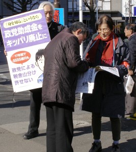 呼びかけに応えて署名する男性＝19日、東京・大塚駅前