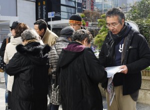参加者の呼びかけに応じて続々と署名する女性ら＝16日、東京・新宿駅前