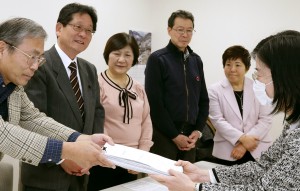 署名を提出する後援会員。すがや俊一区議(左から2人目)、あぜ上三和子都議(同5人目)も同席=26日、都庁