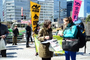「原発ゼロ」の署名に応じる通行人=11日、東京・新宿駅前