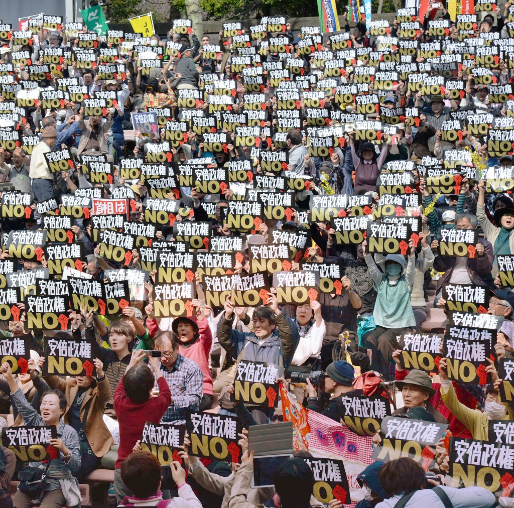 安倍政権ノーのプラカードをかかげる集会参加者＝22日、東京・日比谷野外音楽堂