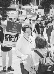 （写真）「戦争法案ストップ」と街頭で宣伝する人たち。車上から訴えるのは宮本徹衆院議員＝１７日、東京・新宿駅南口