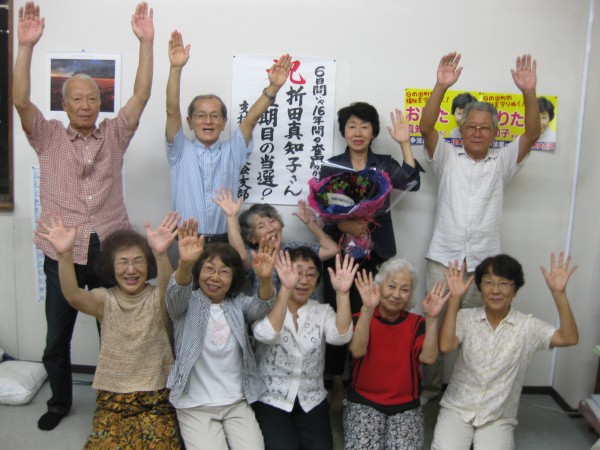 支援者と当選を喜び合う、おりた氏（後列右から２人目）＝23日、東京都日の出町