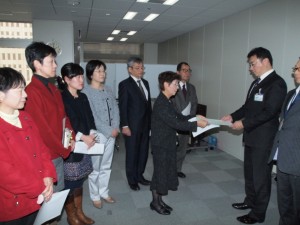 都中央卸売市場の飯田部長（右端）に申し入れる、（左から）河野、和泉、米倉、尾崎、曽根、かち、松村の各都議＝4日、東京都庁【写真提供「しんぶん赤旗」】