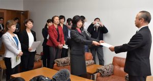 高橋市長（右）にセクハラ疑惑の解明を求める声明文書を手渡す女性議員有志＝12日、東京都狛江市庁