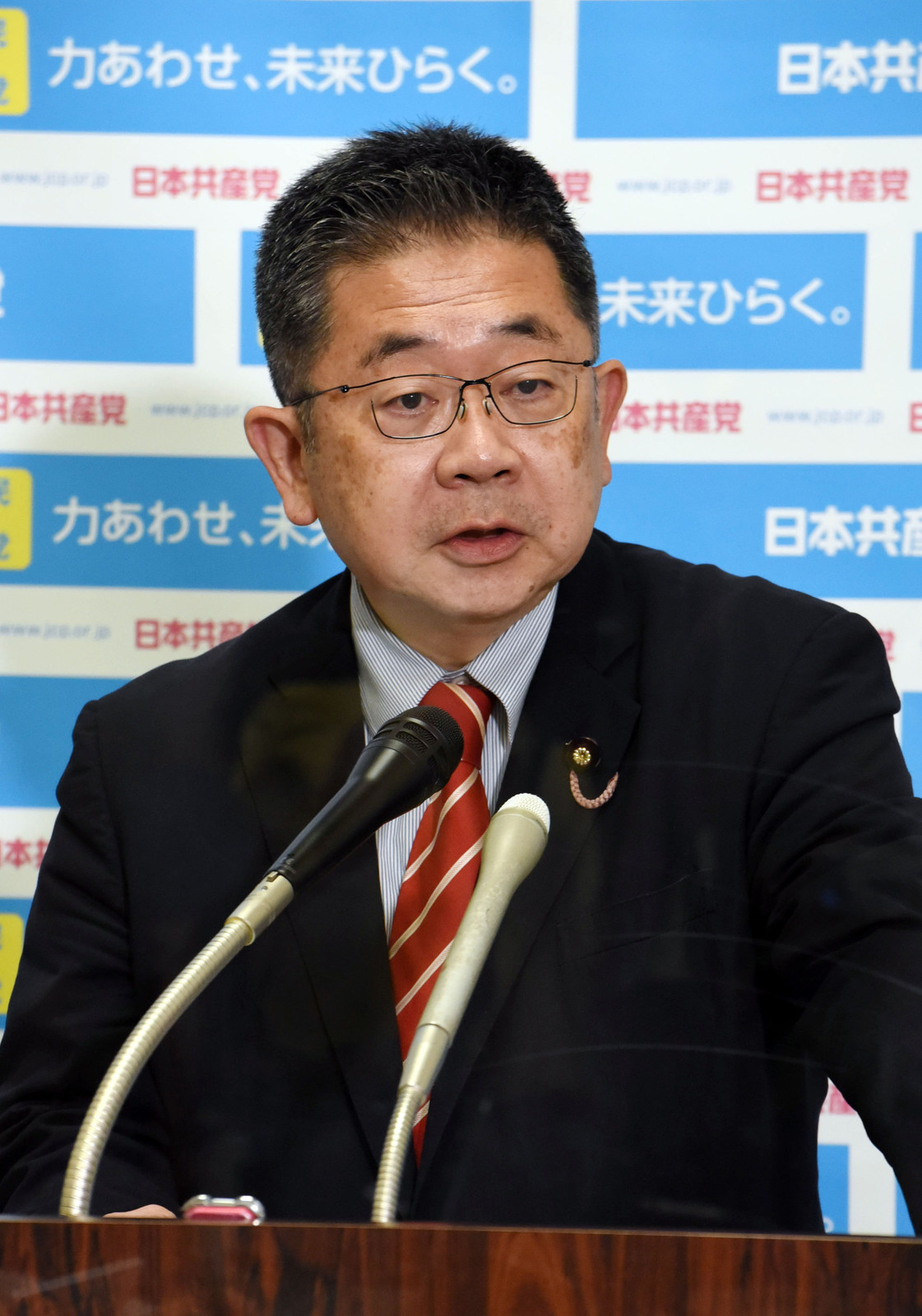 記者会見する小池晃書記局長